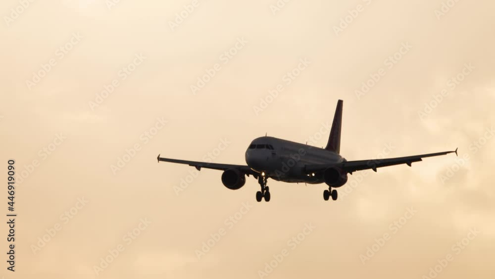 Airliner silhouette in golden sunset sky Airliner silhouette in golden sunset sky