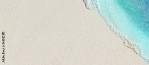 Tropical beach background with sea waves, white sand - summer holiday background. Travel and beach vacation, copy space for text.