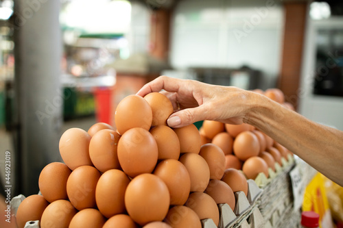 Senior caucasian woman buying chicken eggs at market place.