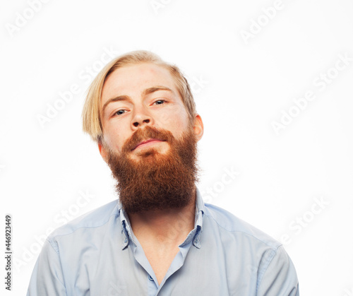 Serious thoughtful male with ginger beard, dressed casually isolated over white background.