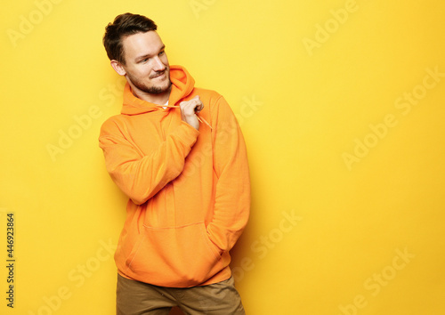 young man posing over yellow background