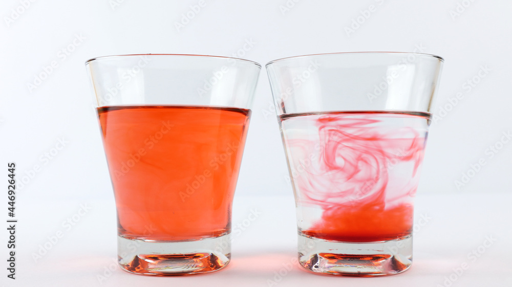 Diffusion of colors in a glass filled with water and another glass filled with vinegar. The science of diffusion Diffusion of colors in a glass filled with water and another glass filled with vinegar. The science of diffusion