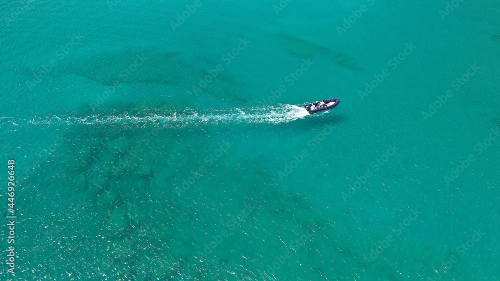 Aerial drone photo of inflatable rib speed boat cruising in tropical exotic bay with emerald sea Aerial drone photo of inflatable rib speed boat cruising in tropical exotic bay with emerald sea