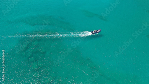 Aerial drone photo of inflatable rib speed boat cruising in tropical exotic bay with emerald sea © aerial-drone