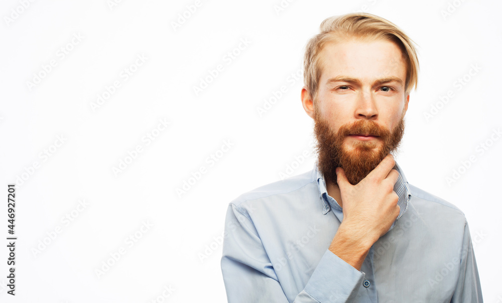 Serious thoughtful male with ginger beard, dressed casually isolated over white background. Serious thoughtful male with ginger beard, dressed casually isolated over white background.