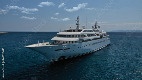 Aerial drone photo of luxury mega yacht with wooden deck and pool facilities anchored in Mediterranean open ocean deep blue bay © aerial-drone