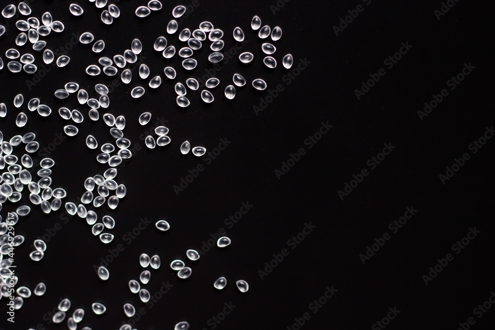 white granules of rubber and polypropylene on a black background. Plastics and polymers industry. Copy space