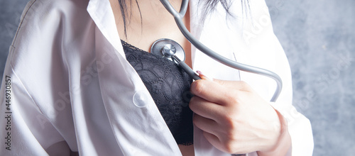 sexy nurse in bra listens to her heartbeat with a stethoscope