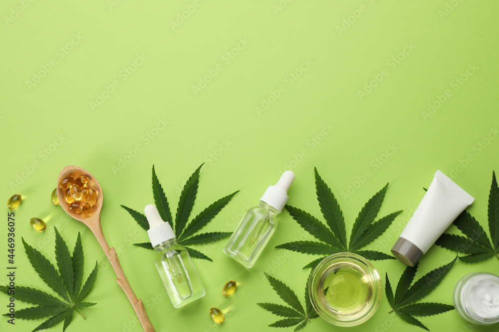 Flat lay composition with hemp leaves, CBD oil and THC tincture on green background, space for text Flat lay composition with hemp leaves, CBD oil and THC tincture on green background, space for text