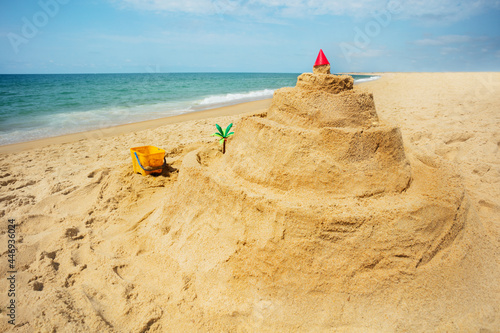 Side view of sand castle and toys on the sea beach