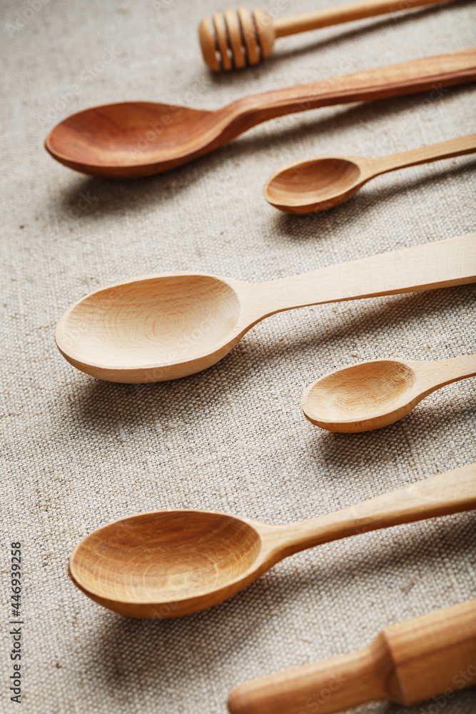 Wooden spoons made of natural wood on burlap fabric as a craft. Wooden spoons made of natural wood on burlap fabric as a craft.