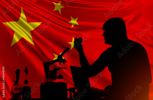 Fellow at institute of virology in China. Silhouette of laboratory assistant on background PRC flag. Development virology in lab in China. Chinese scientist with test tube in his hands. Virology man