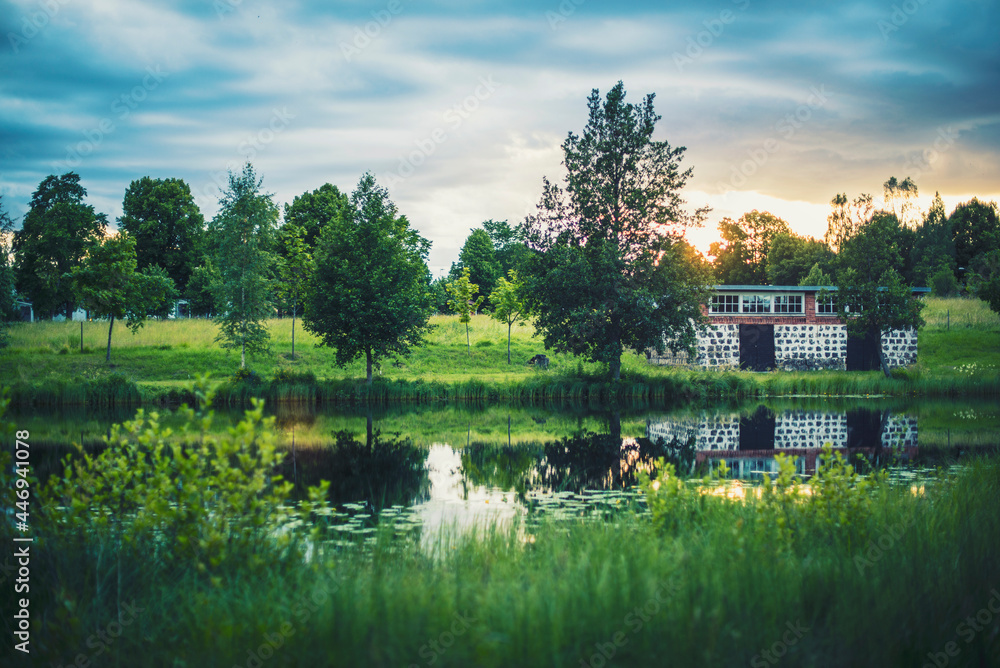 Fototapeta premium Pastoral scenery from rural Sweden. Depicting a scenic sunset over the village Stjärnsund in Dalarna.