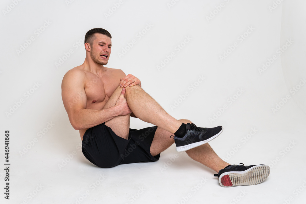A man's kneecap hurts on a white background ache hurt injury, sick white massage stress, hand holding. Hold red therapy, disease suffer attractive A man's kneecap hurts on a white background ache hurt injury, sick white massage stress, hand holding. Hold red therapy, disease suffer attractive