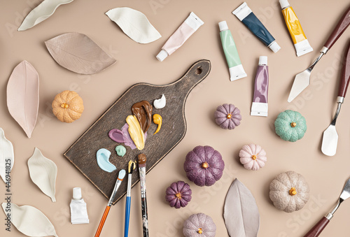 Hobby background with handmade clay leaves and pumpkins, paint brushes and art accessories. DIY, craft decoration for fall holidays. Flat lay, top view