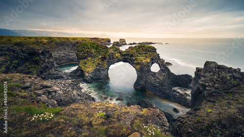 Atmospheric wide-angle view of Gatklettur arch rock formation, Arnarstapi, Snæfellsnes peninsula, Iceland 2021