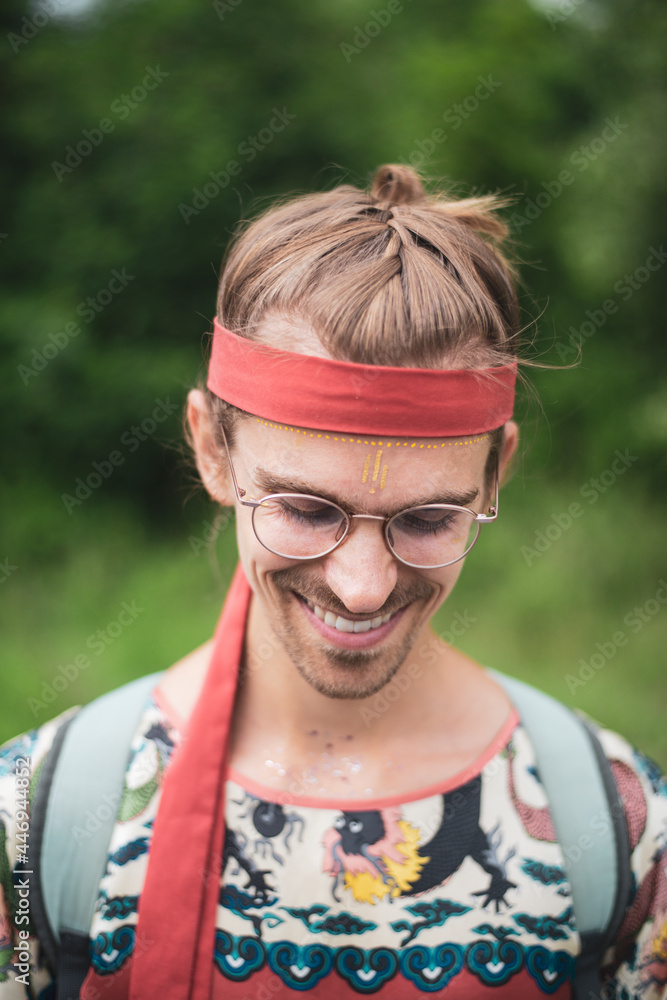 Colourful queer man with glasses smiles facepaint in nature Colourful queer man with glasses smiles facepaint in nature