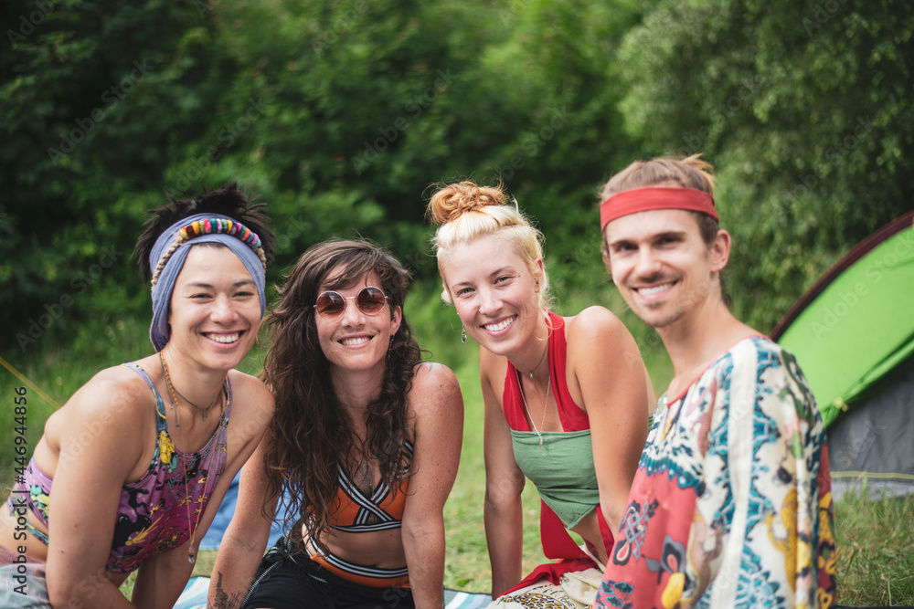 Colourful group of queer friends smile at festival camp in nature Colourful group of queer friends smile at festival camp in nature