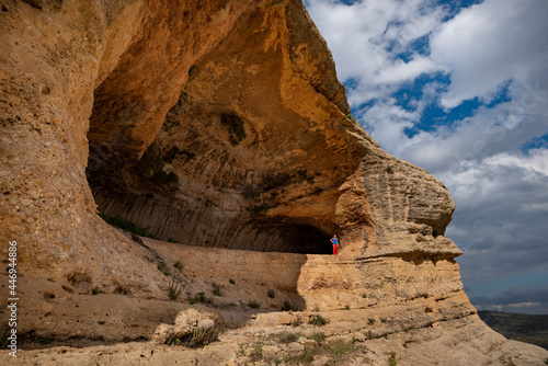 A women hiking a scenic trail under a giant overhang Caves of Zaen photo