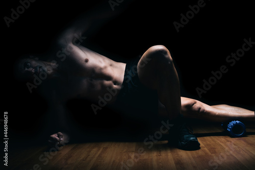 Muscular man lying on the floor doing stretching exercises