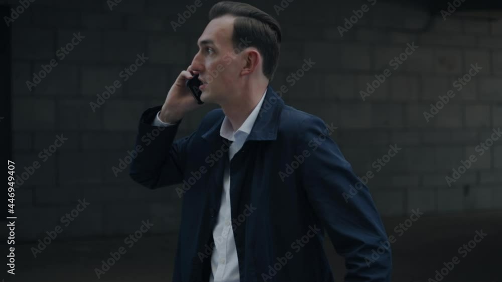 A businessman with a suitcase is talking on the phone at the airport. A businessman with a suitcase is talking on the phone at the airport.