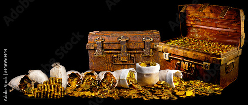 Stacking lots of gold coins in treasure chest old on black background