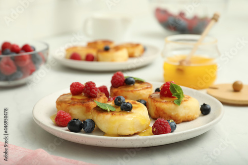 Delicious cottage cheese pancakes with fresh berries and mint on white table