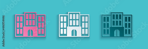 Paper cut Hotel building icon isolated on blue background. Paper art style. Vector