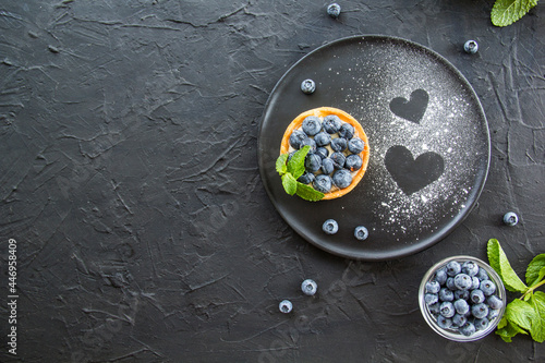 A healthy tasty dessert of cheese blueberry tart. Creative atmospheric decoration