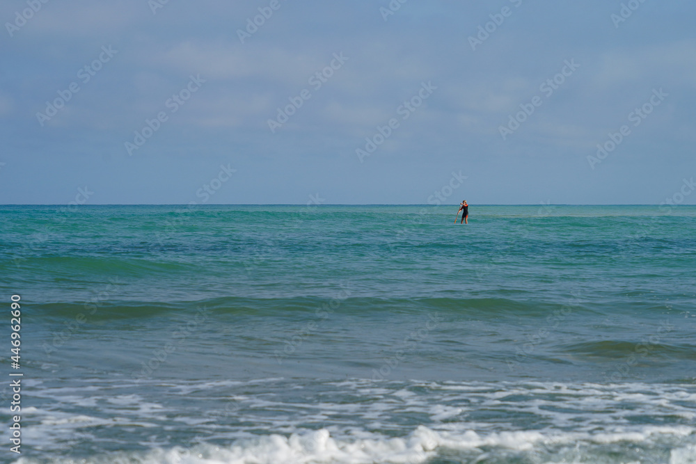 Une personne debout sur un paddle sur l'océan atlantique calme