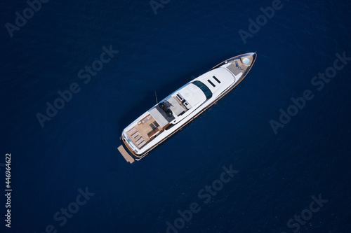 A huge white super Mega yacht on blue water in Italy. White yacht open sea aerial view. Super yacht on blue water top view. © Berg