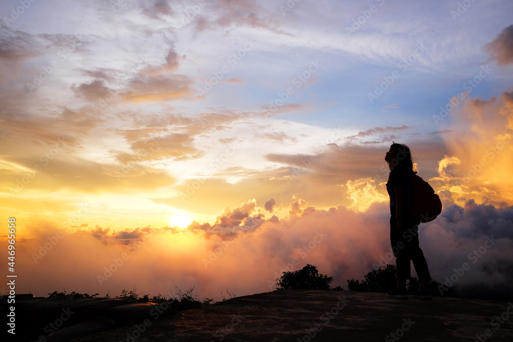 Beautiful silhouette of asian woman with Destination and paradise of golden sunrise and sunset shining to the mist and fog in the jungle on the valley mountain. Succsessful and hope of life Concept