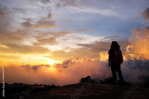 Beautiful silhouette of asian woman with Destination and paradise of golden sunrise and sunset shining to the mist and fog in the jungle on the valley mountain. Succsessful and hope of life Concept © cocorattanakorn