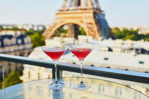 Canvas Print Two Cosmopolitan cocktails in traditional martini glasses with view to the Eiffe