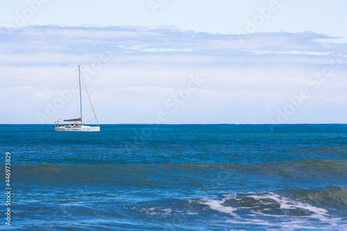 Sailing boat stays close to shore on a calm day.Copy space