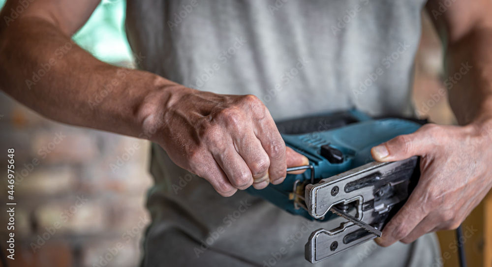 Close up electric tool for sawing wood in hands of man. Close up electric tool for sawing wood in hands of man.