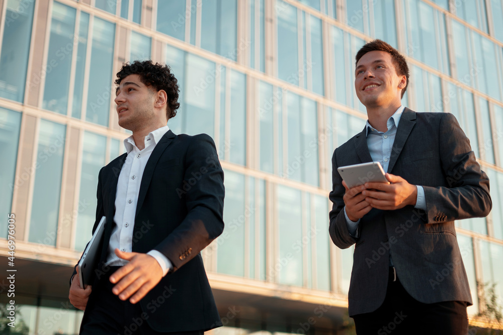 Economists are discussing further actions on the project. Business and youth concept. Men go to work brokers hold gadgets in their hands. Economists are discussing further actions on the project. Business and youth concept. Men go to work brokers hold gadgets in their hands.
