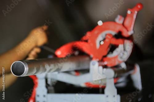 Engineer make a pipe thread by lathe Machine tool Selective focus foreground Black background with copy space.
