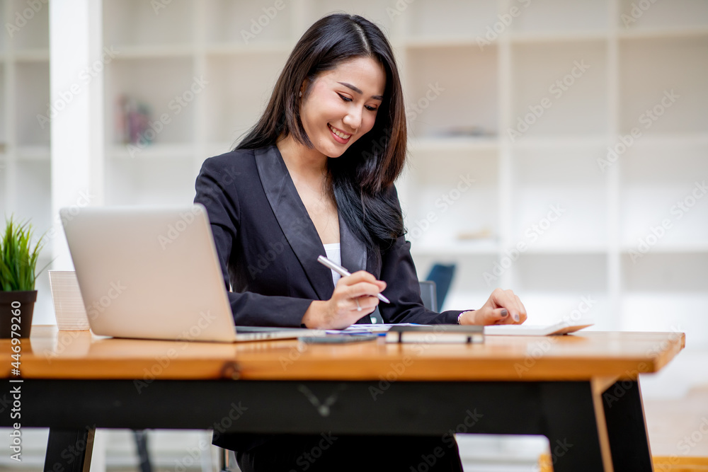 Portrait of Happy Young attractive business woman using digital laptop computer. do math finance on wooden desk, tax, accounting, report statistics and analytical research technology concept. Portrait of Happy Young attractive business woman using digital laptop computer. do math finance on wooden desk, tax, accounting, report statistics and analytical research technology concept.