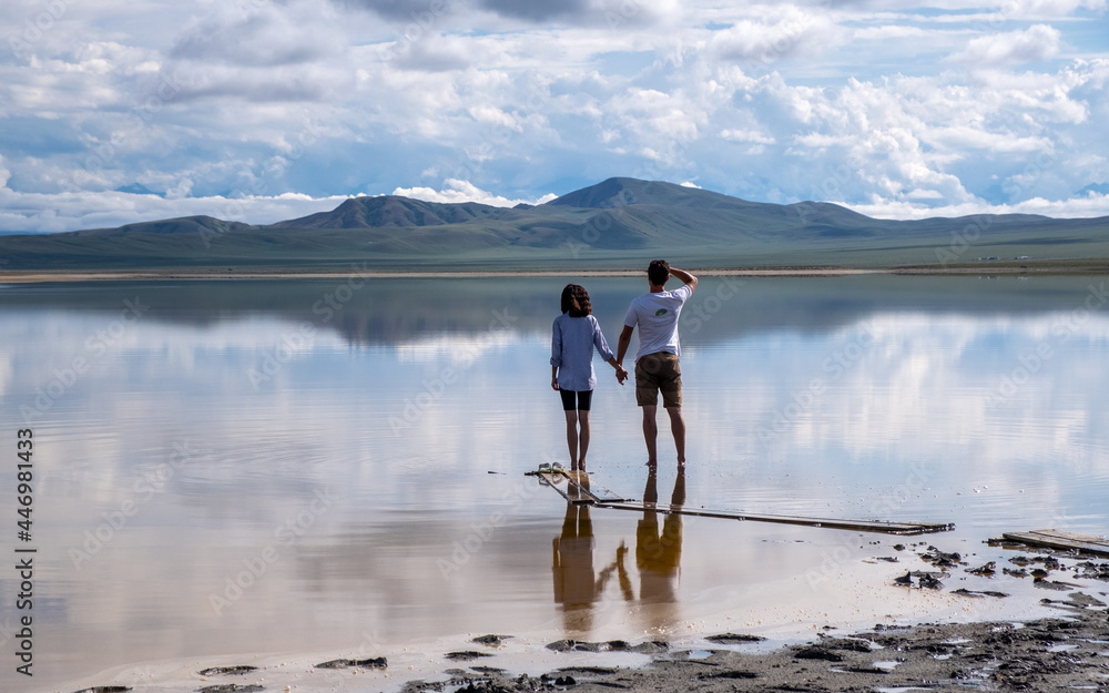 a guy and a girl on the shore of a high mountain lake a guy and a girl on the shore of a high mountain lake
