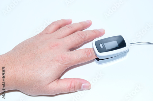 Pulse oximeter on the index finger on a white background. Measurement of blood oxygen and pulse. View from above. Lung disease. Concept