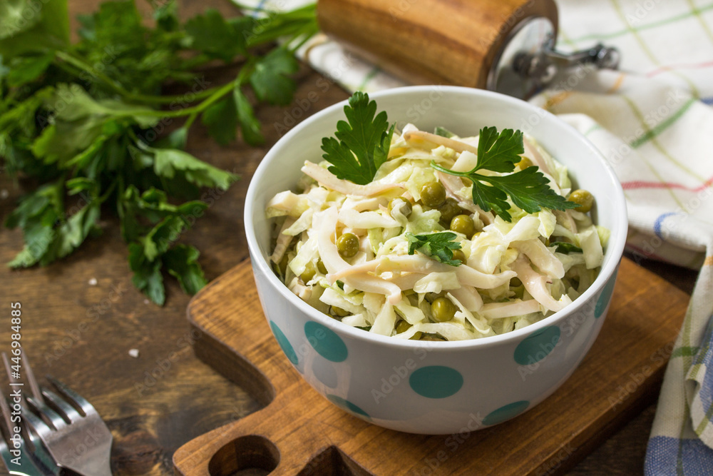 Salad with fresh cabbage, calamary, cucumber and green peas in a bowl on a rustic table. Salad with fresh cabbage, calamary, cucumber and green peas in a bowl on a rustic table.