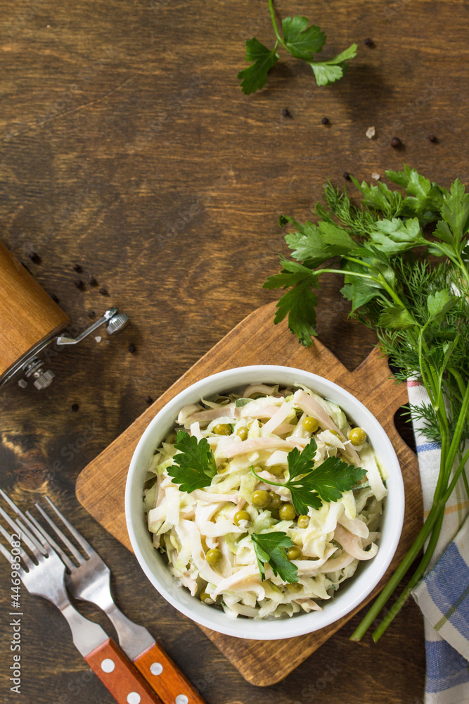Salad with fresh cabbage, calamary, cucumber and green peas in a bowl on a rustic table. Top view flat lay background. Copy space. Salad with fresh cabbage, calamary, cucumber and green peas in a bowl on a rustic table. Top view flat lay background. Copy space.