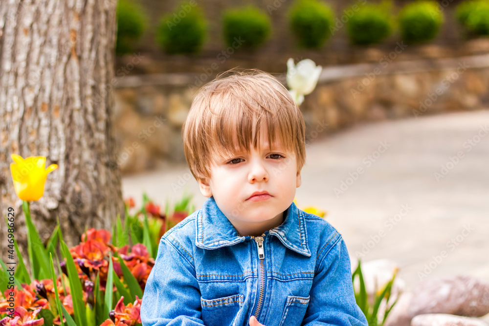 Close-up portrait of a small child smiling outdoors on a green background. Close-up portrait of a small child smiling outdoors on a green background.