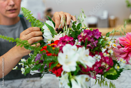 Crop female florist preparing a bunch of flowers
