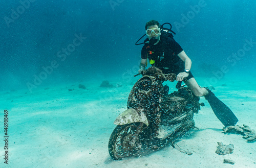 diver posing on motorbike on the ocean floor at Phuket photo