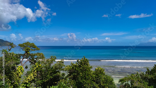 Calm Indian Ocean  green trees and bright sky  Seychelles