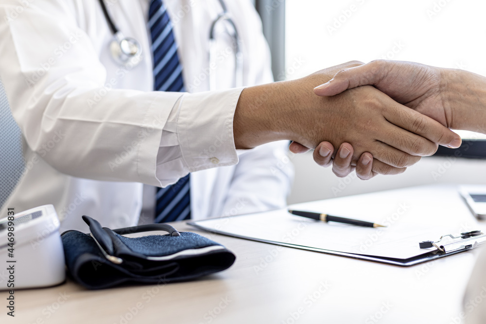 The doctor and patient shake hands after the examination and the results have been reported. concept of disease diagnosis and encouragement in the treatment of serious diseases.