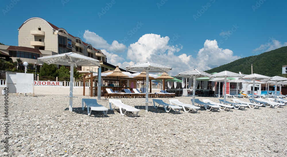 Umbrellas on the beach in the resort village of Nebug, Krasnodar Territory, Russia - June 30, 2021