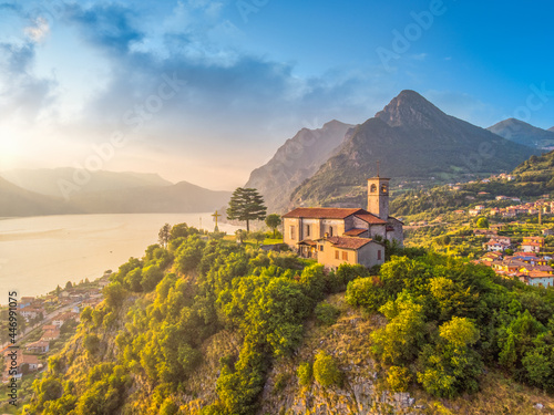 Beautifull aerial panoramic view from the drone to the Iseo lake with church on top of the hill, Lombardy, Italy